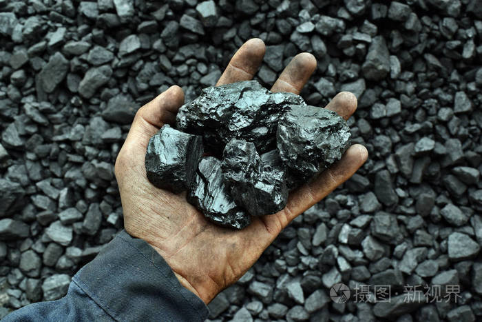 工人矿工手中的煤。图片可用于煤炭开采、能源或环境保护的理念